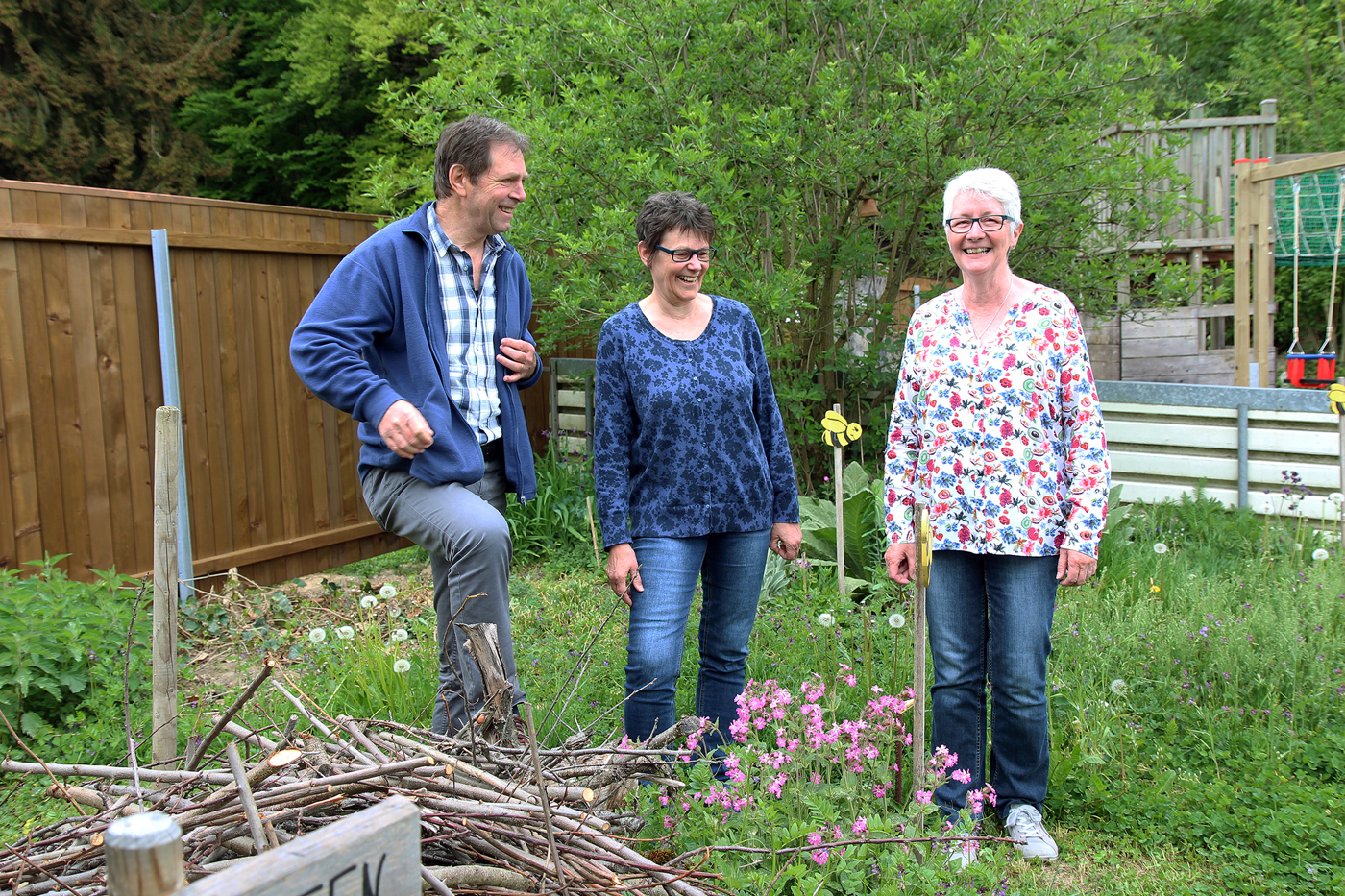 Armin und Katrin Meier vom Vogel- und Naturschutzverein Wiler und ihre Präsidentin Marianne Chatzigeorgiou (ganz rechts) freuen sich über das grosse Interesse der Bevölkerung an ihrem Naturgarten. Dieser liegt an perfekter Lage – gleich neben dem Spielplatz. © Daniela Pauli