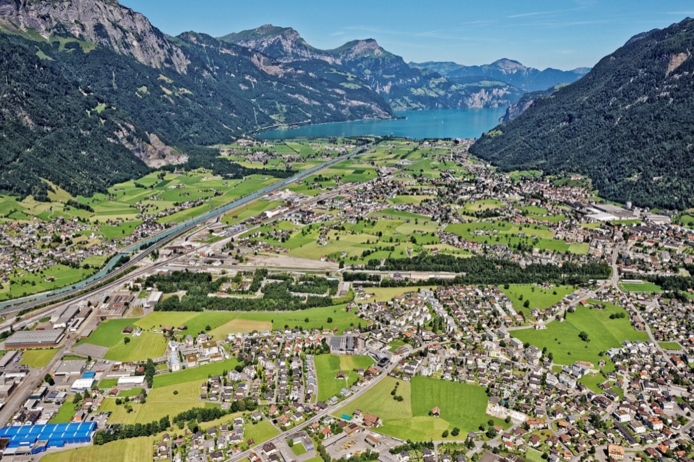 Dieses Luftbild, aufgenommen in Richtung Urnersee, zeigt, wie stark die Reussebene bei Altdorf UR zersiedelt ist. Von einem «haushälterischen» Umgang mit dem Boden kann keine Rede sein. © reportair.ch