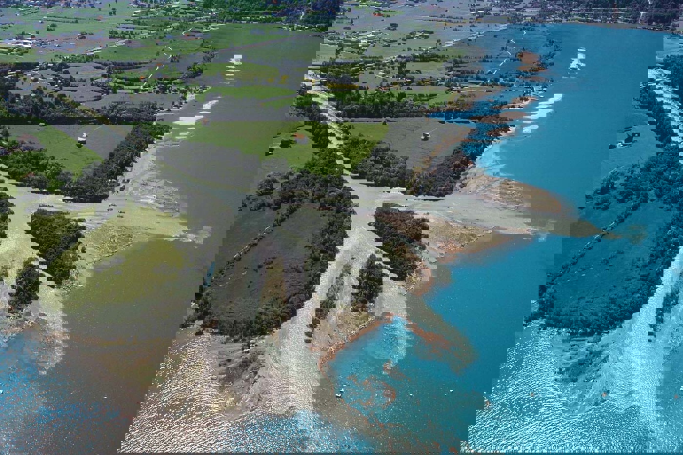 Das Reussdelta im Jahr 2005. Im oberen Teil des Bildes sind die aufgeschütteten Inseln zu sehen. Die drei vorderen Inseln sind die zugänglichen Badeinseln, die drei hinteren die Naturschutzinseln mit der Ringinsel in der Mitte. © Archiv Seeschüttung